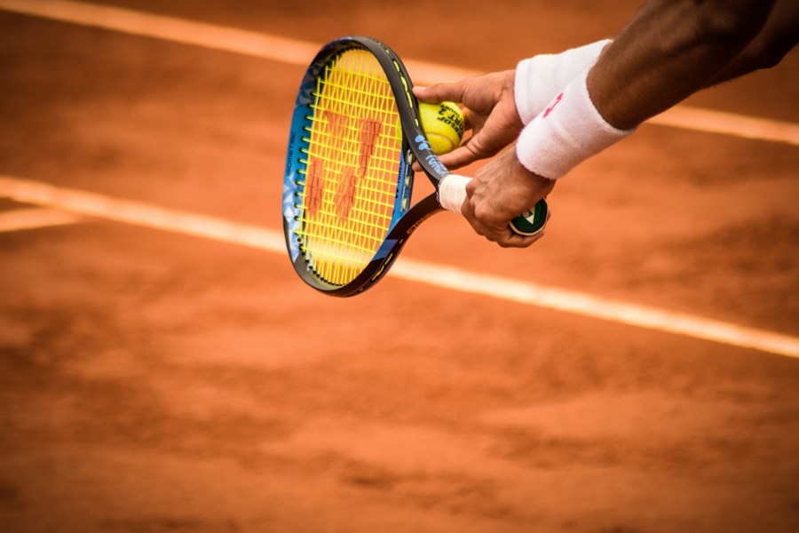 A racket and ball lying on clay